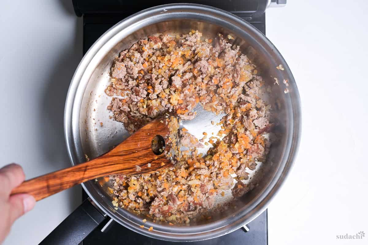 deglazing a stainless steel pan to make spaghetti meat sauce