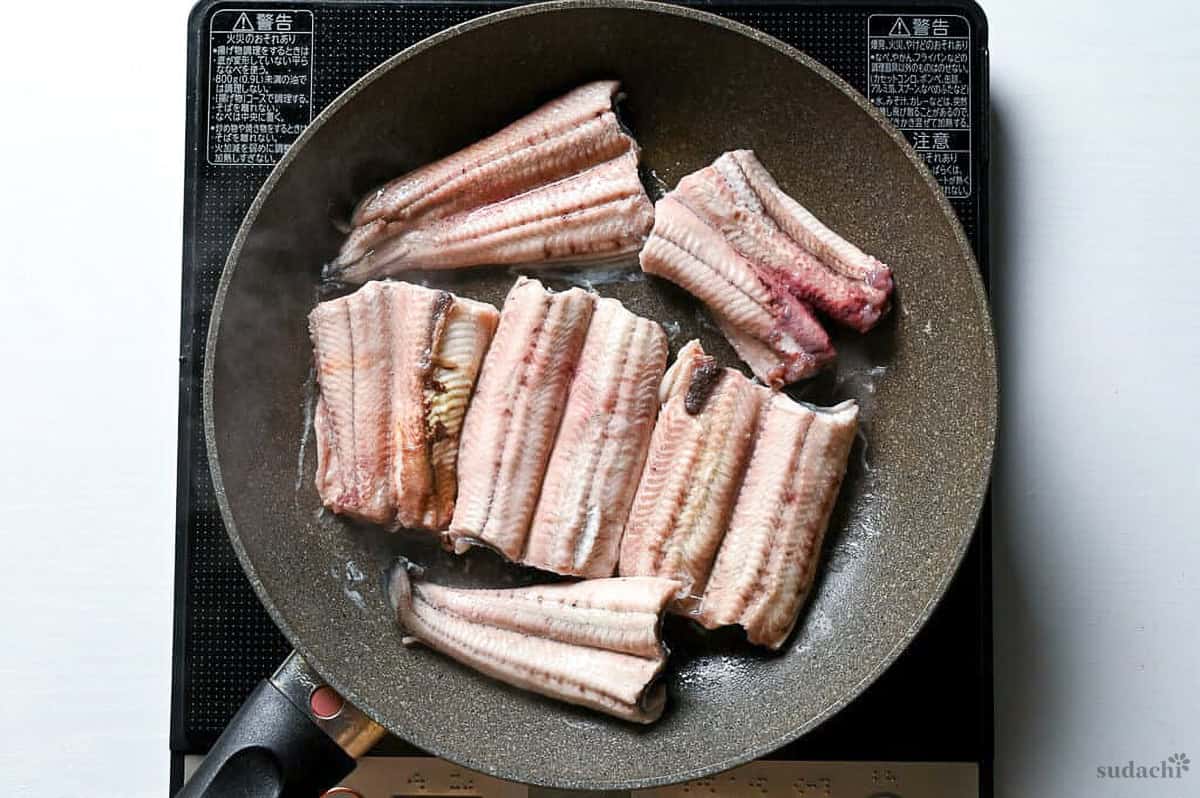 eel fillets in a frying pan to make unagi