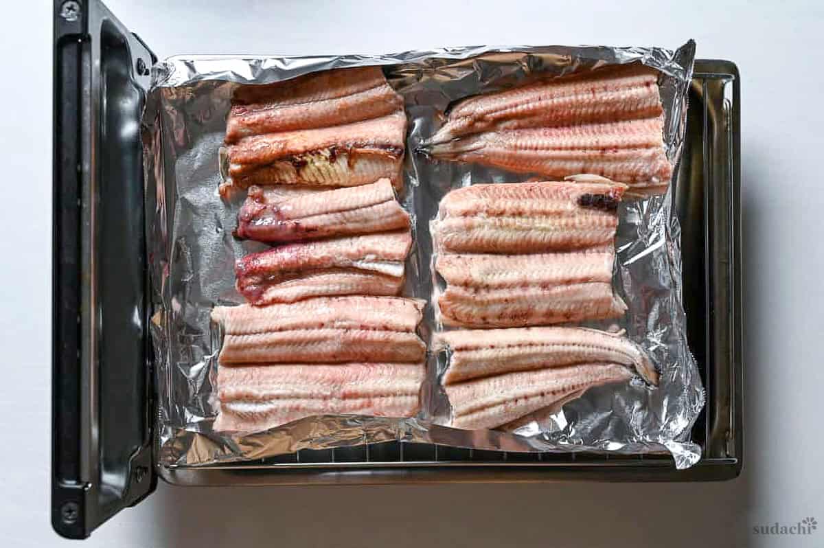 eel (unagi) fillets on foil on a Japanese fish grill