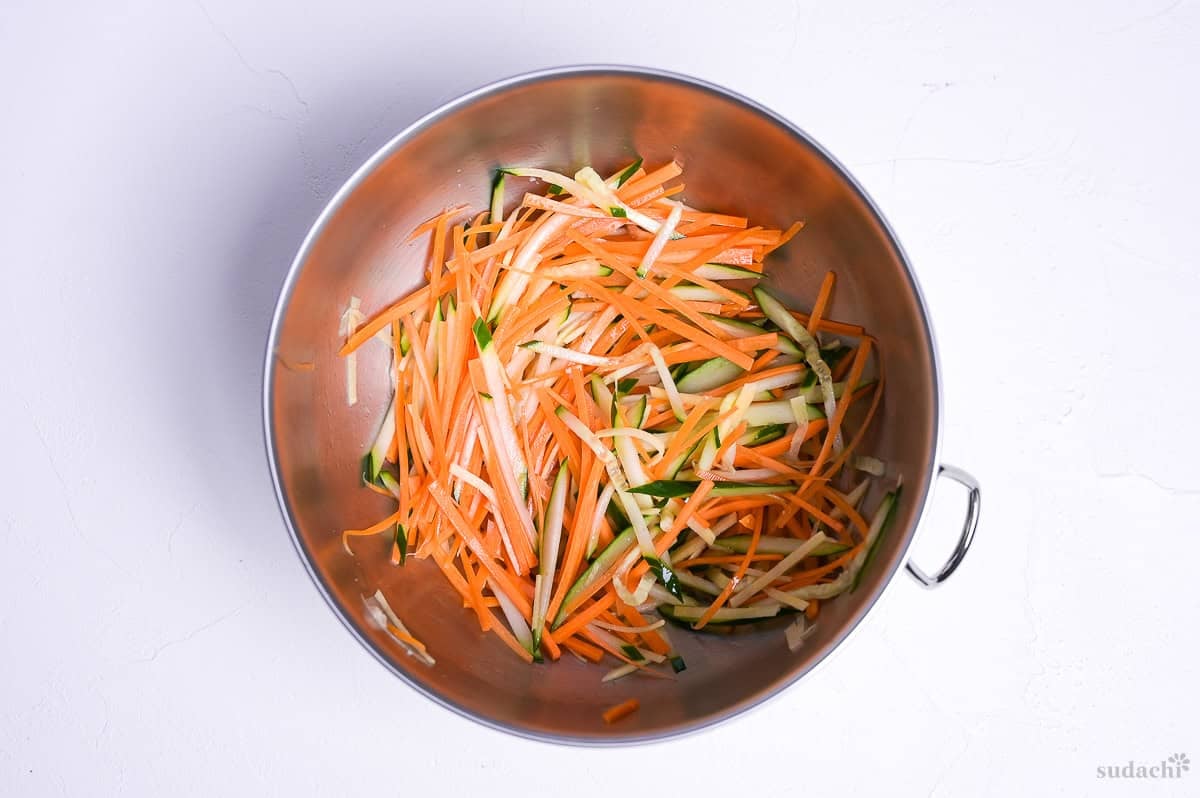 carrot, ginger and cucumber julienned and salted in a bowl