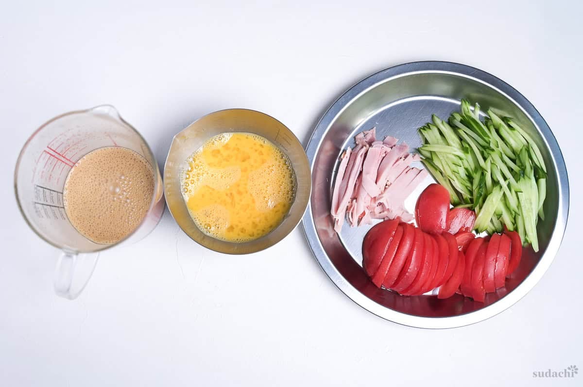 Sauce, egg and toppings prepared to make hiyashi chuka.