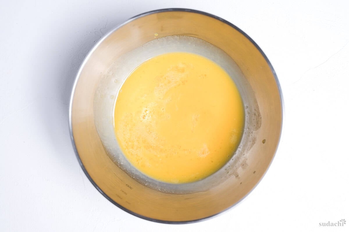 whisked and strained egg in a steel mixing bowl