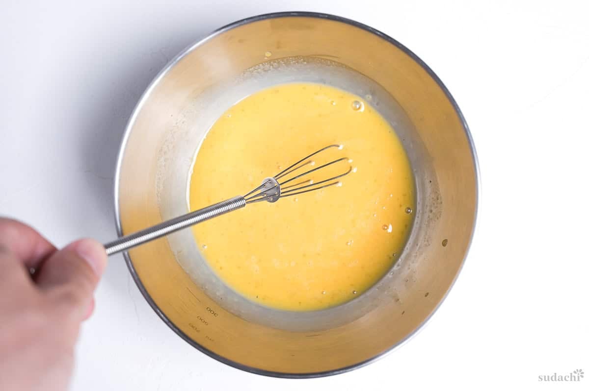 mixture to make kinshi tamago (Japanese shredded egg crepe) in a steel mixing bowl with mini whisk