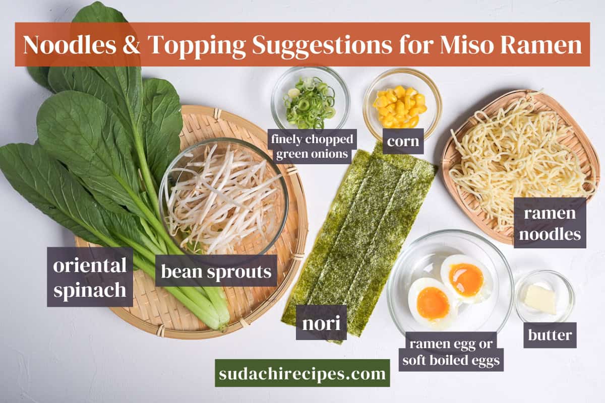 Noodles and topping suggestions for miso ramen on a white background. From left to right: oriental spinach, bean sprouts, finely chopped green onions, nori, corn, ramen eggs or soft boiled eggs, ramen noodles, butter.