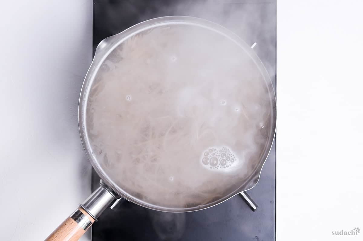 boiling soba noodles in a pot on the stove top