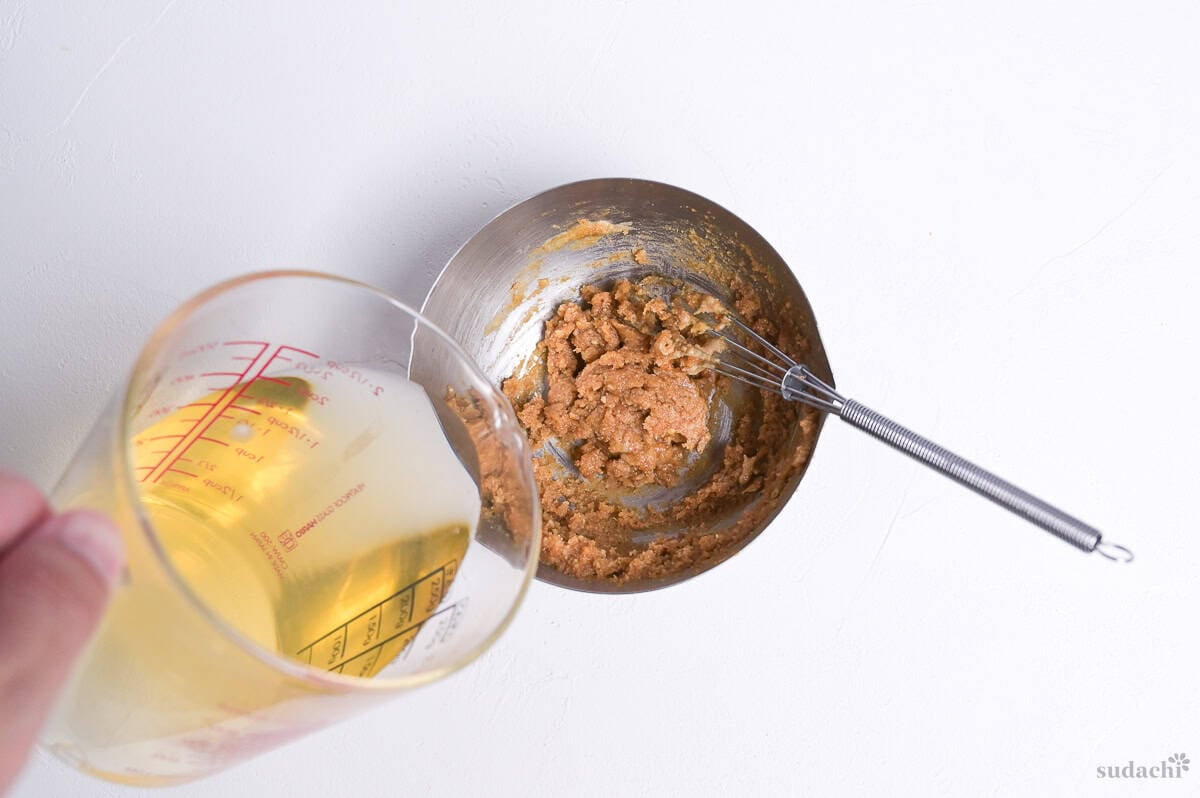 pouring dashi into miso and sesame paste mixture