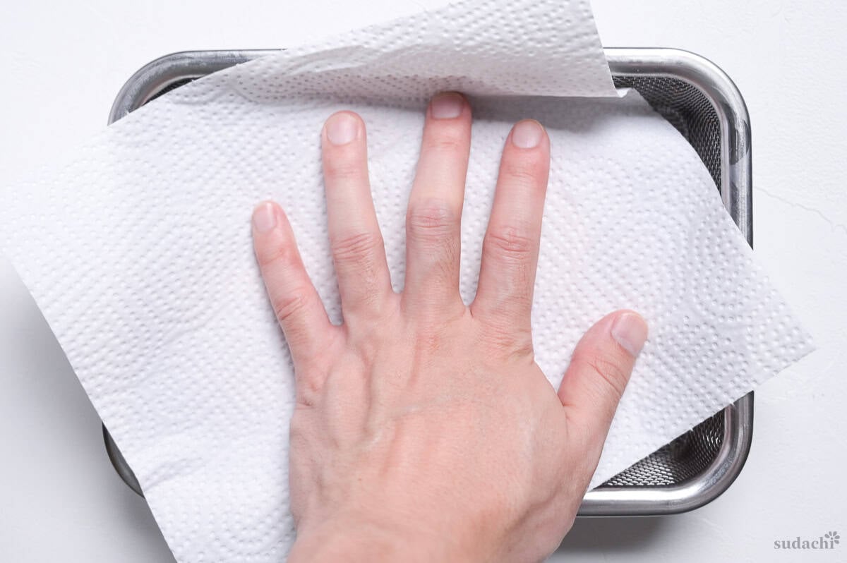 Patting the surface of steak dry with kitchen paper.