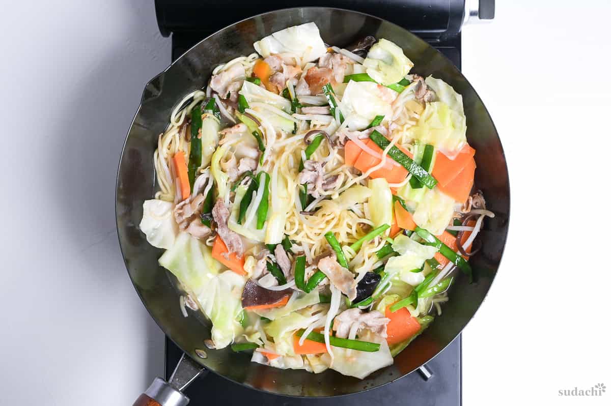 tanmen cooking in a large wok on the stove top