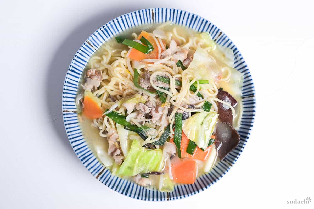 tanmen in a white bowl with blue striped edge