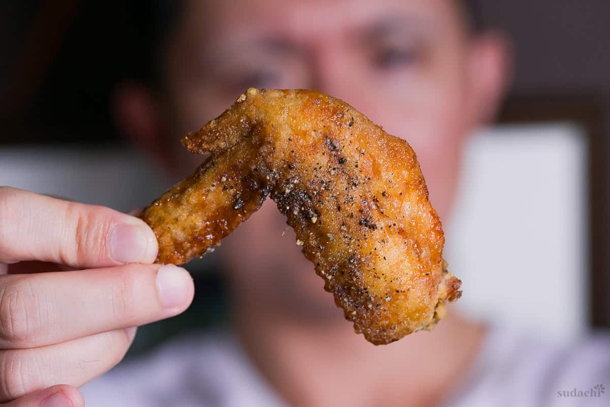 Yuto Omura holding up a Nagoya style deep fried chicken wing (Yamachan inspired tebasaki)