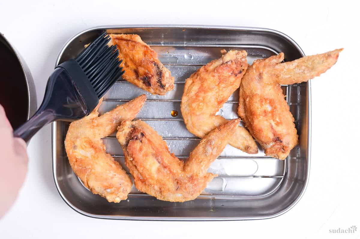brushing fried chicken wings with Nagoya Yamachan inspired sauce