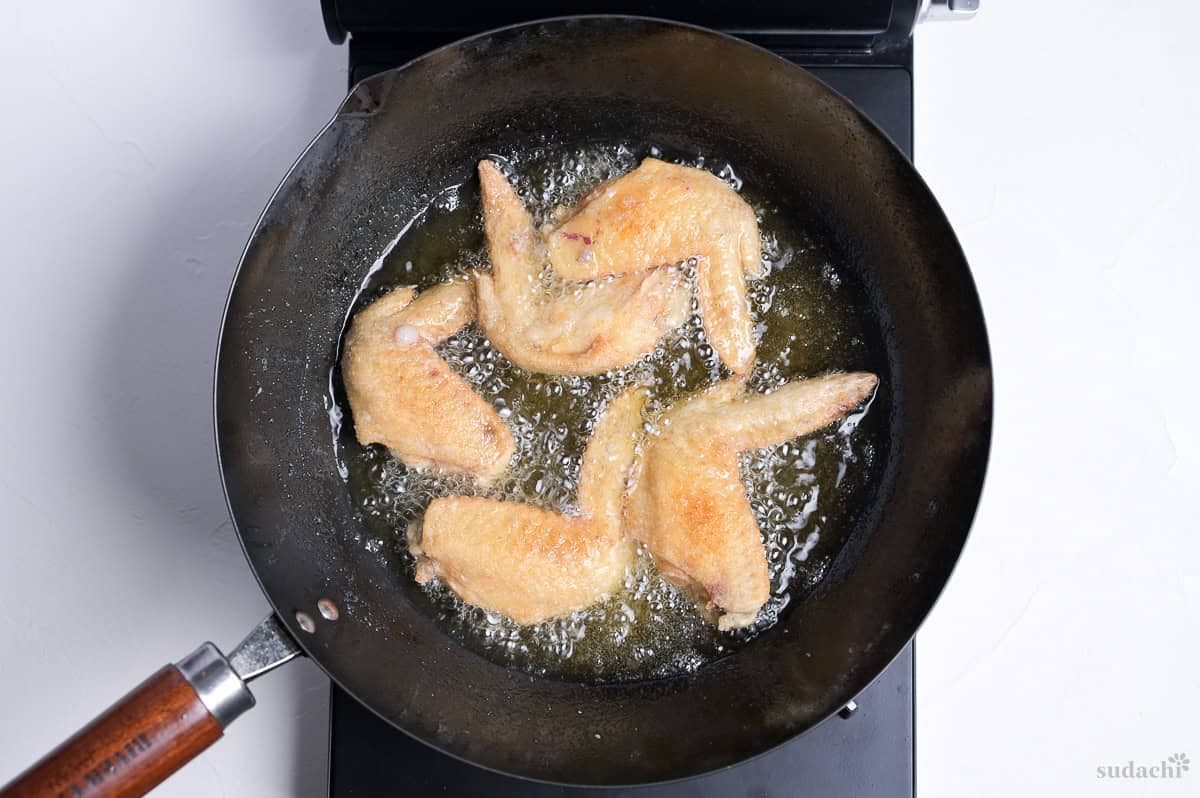 shallow frying flour-dusted whole chicken wings to make Japanese style tebasaki