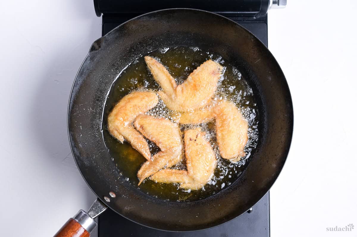 shallow frying flour-dusted whole chicken wings to make Japanese style tebasaki