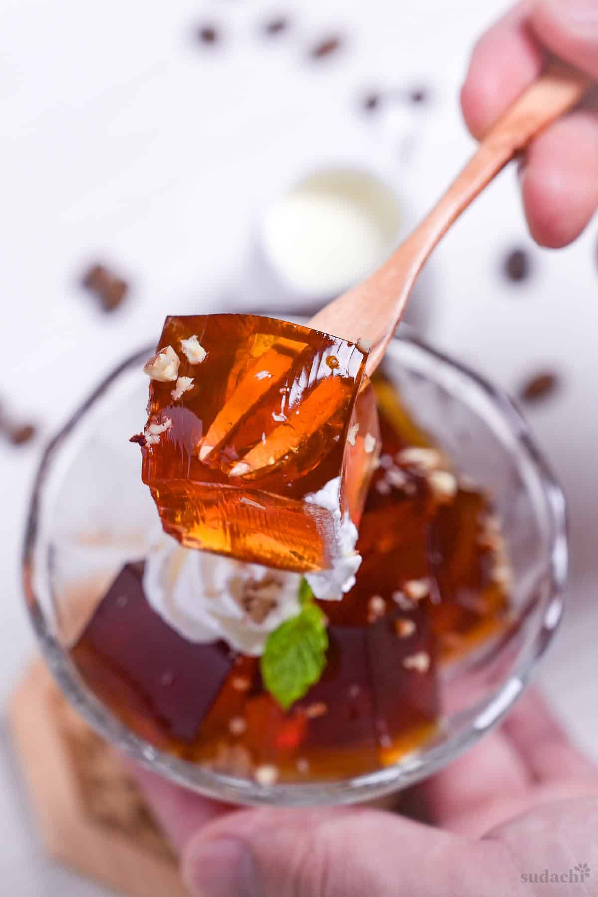 A cube of Japanese coffee jelly held up with a wooden dessert fork