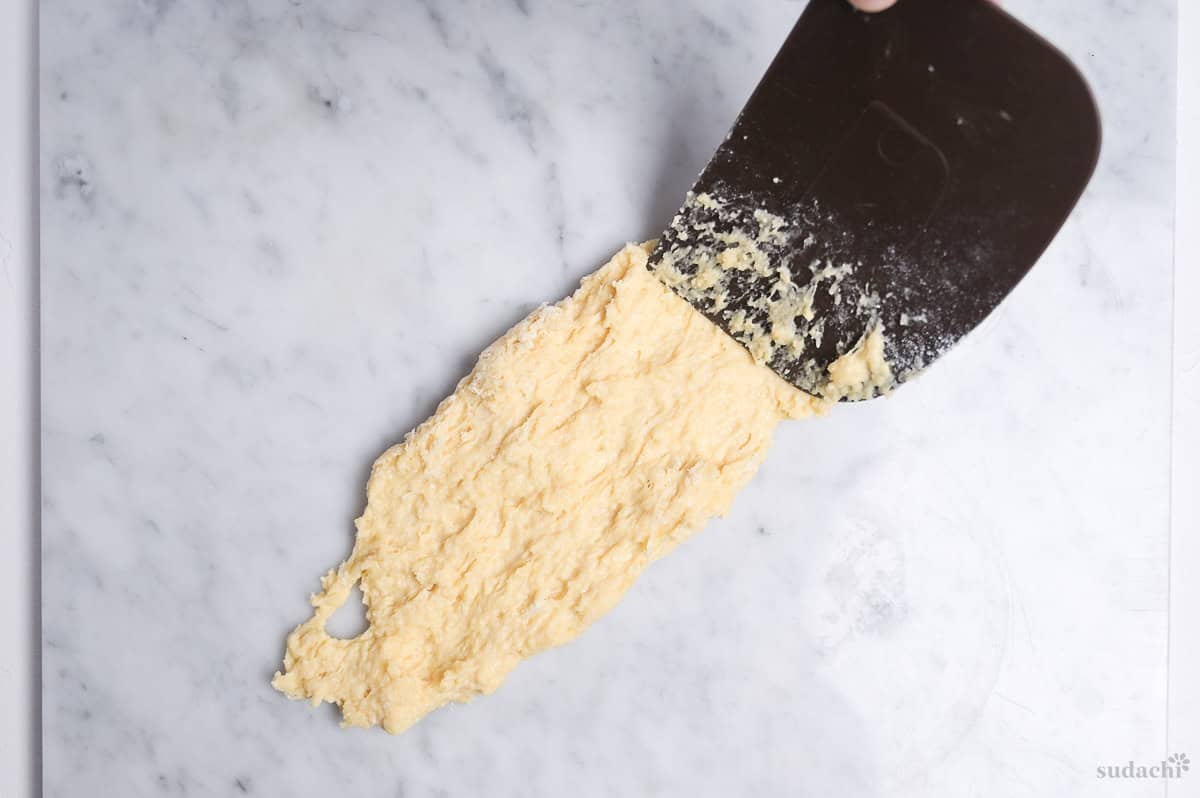 spreading bread dough on marble effect kneading board