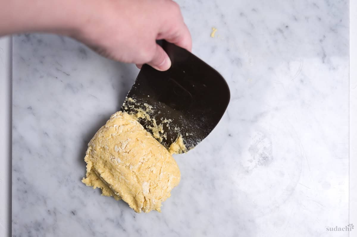 rolling up enriched dough using a plastic bench scraper