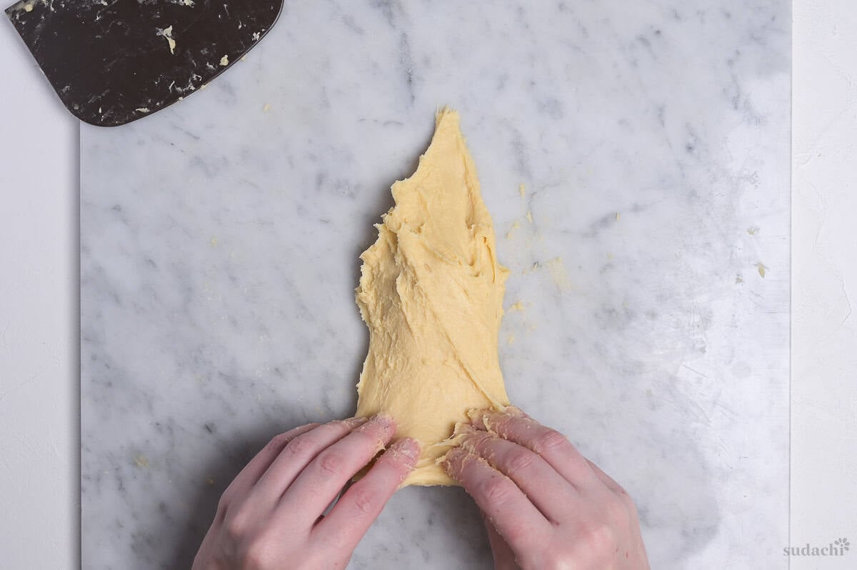 demonstrating slap and fold method with enriched dough (slapping)