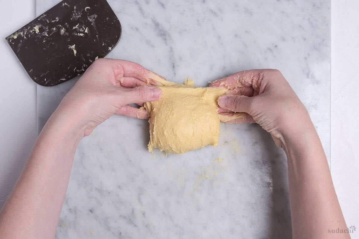 demonstrating slap and fold method with enriched dough (folding)