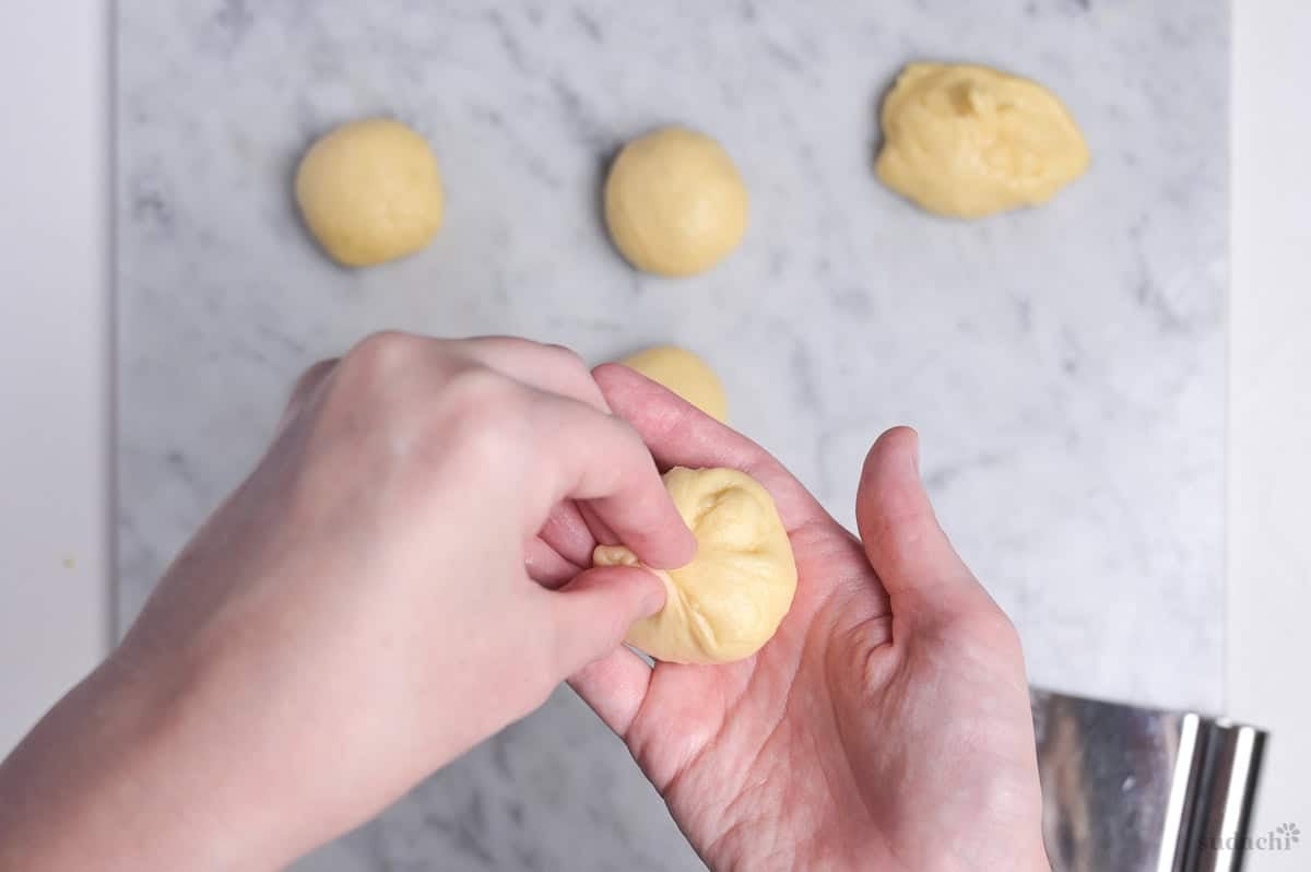 pinching the bottom of the shaped dough