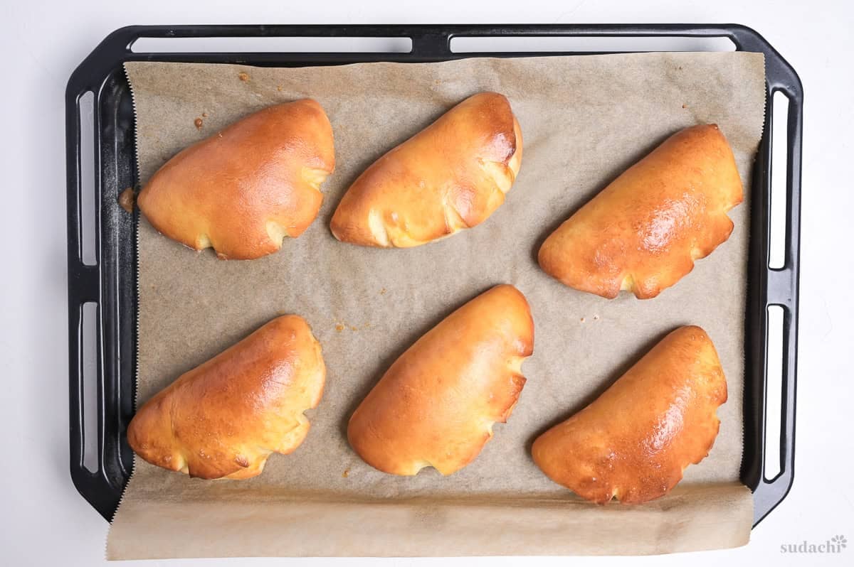 Six cream pan (Japanese sweet custard buns) on a baking tray after baking
