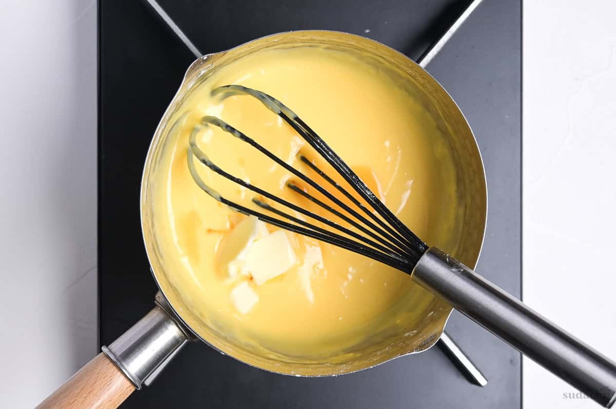 thickened pastry cream in a pan with butter and vanilla