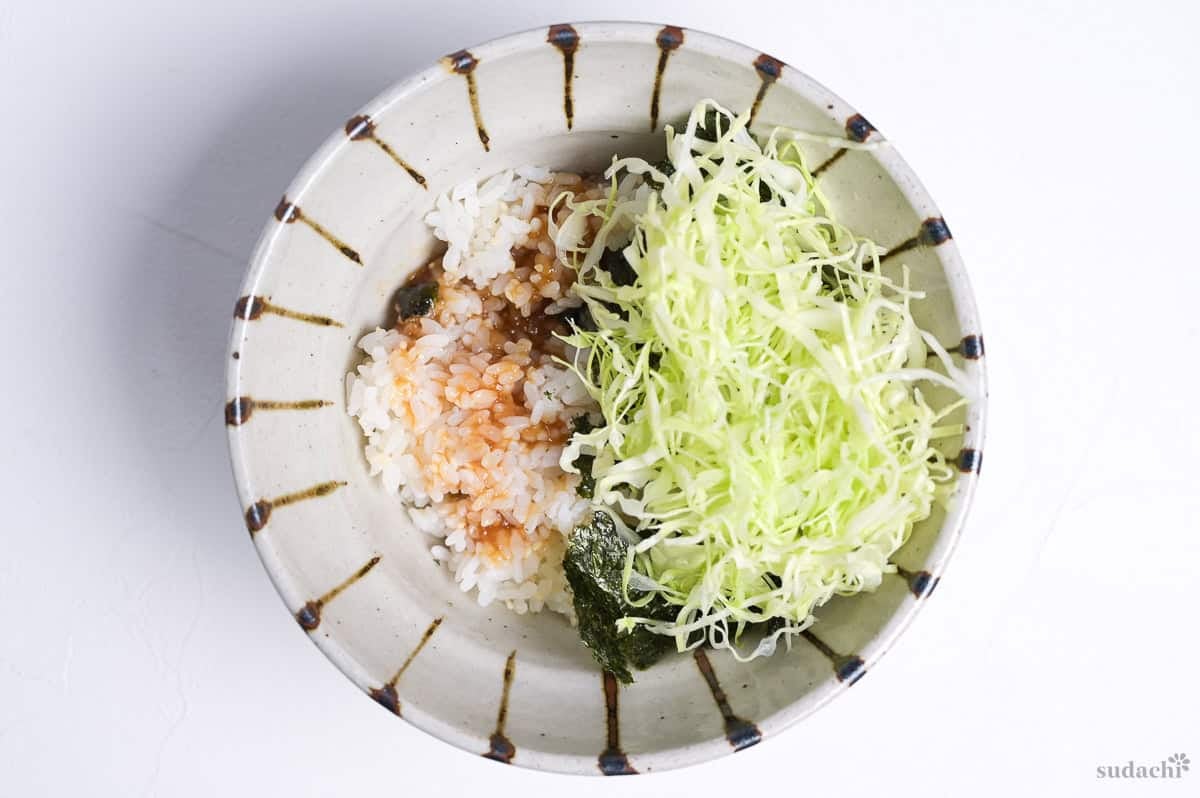 Rice in a bowl topped with shredded cabbage