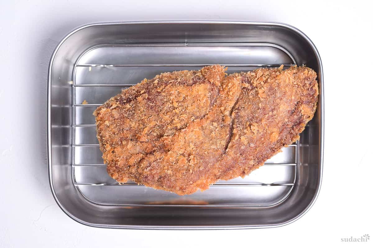 Freshly deep fried gyukatsu (Japanese beef cutlet) on a wire rack