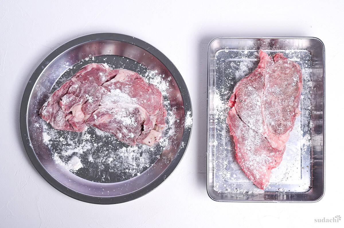 beef steaks dusted with flour on steel trays