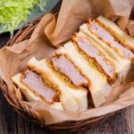 Four katsu sando in a basket lined with parchment paper
