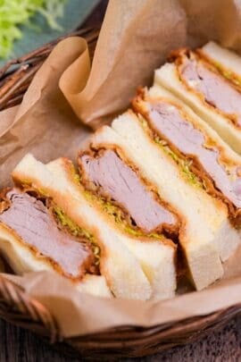 Four katsu sando in a basket lined with parchment paper