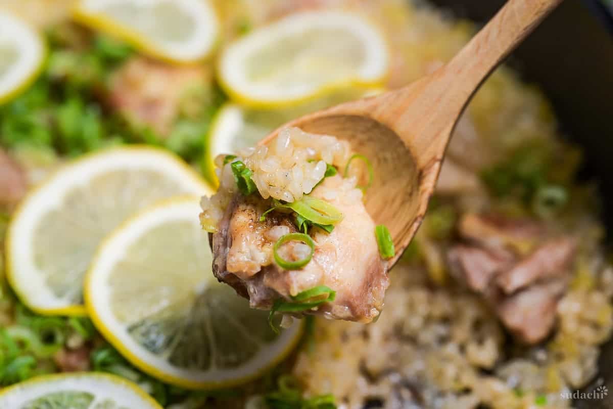 Negi shio paella scooped onto a wooden spoon