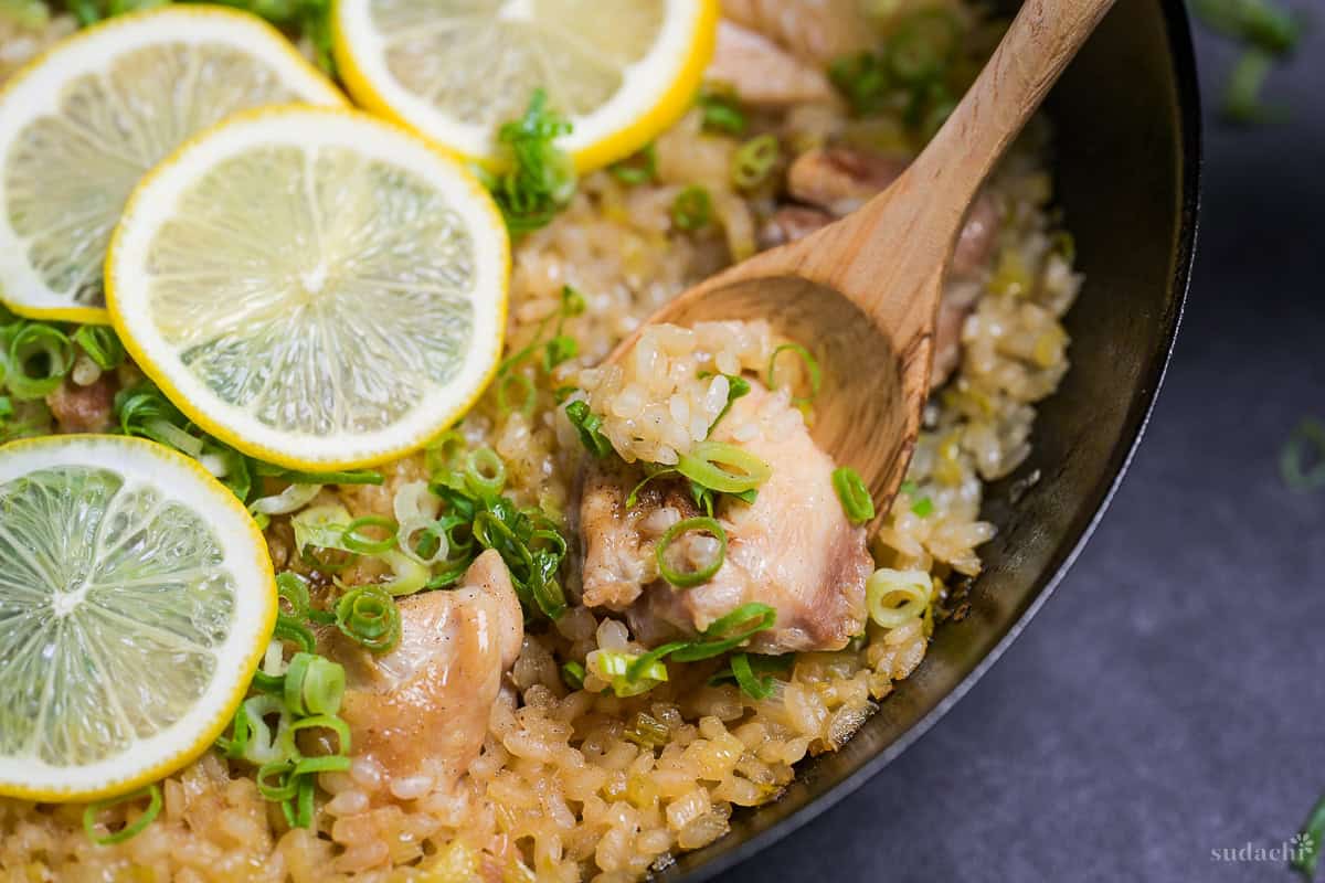 Close up of wooden spoon scooping negi shio paella