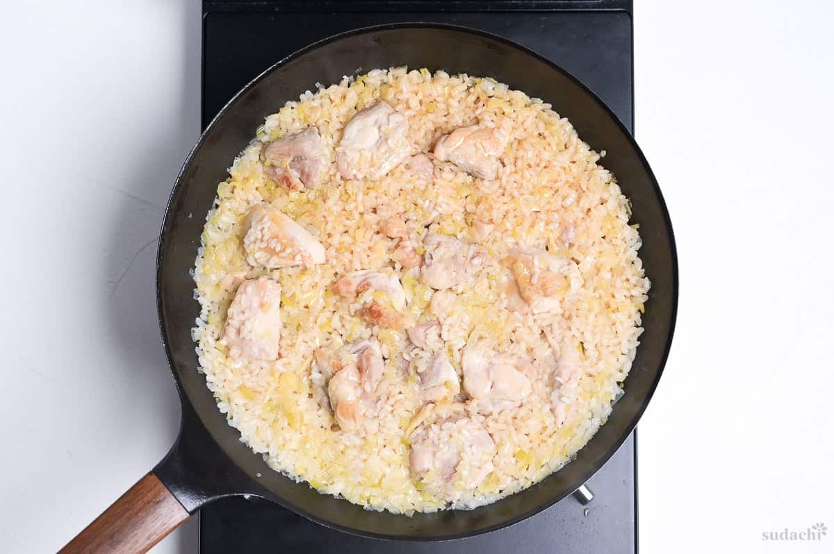 negi shio paella cooked in a frying pan on stove top, with lid removed.