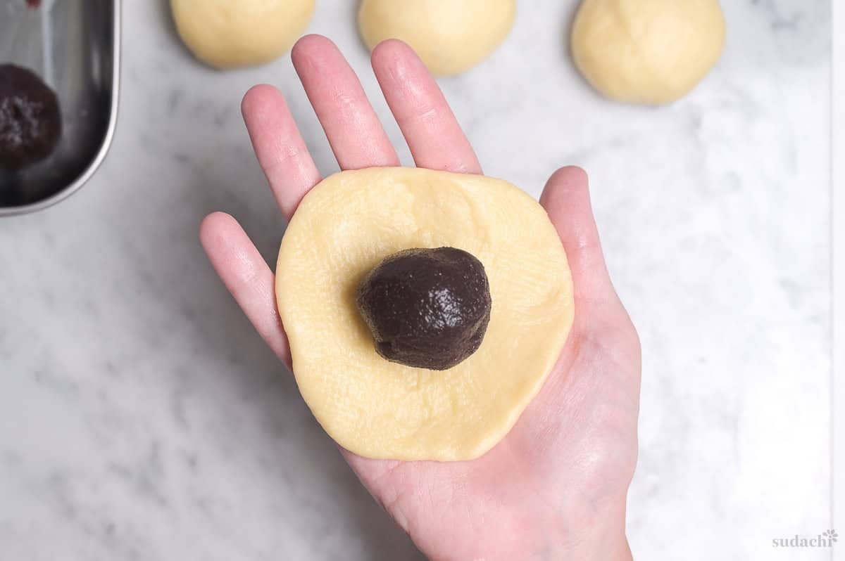 sweet bread dough rolled flat with a ball of anko in the center
