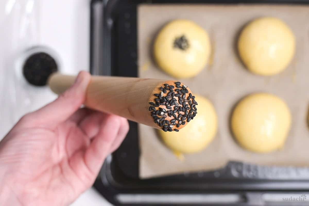 dampened rolling pin with black sesame seeds stuck to the end