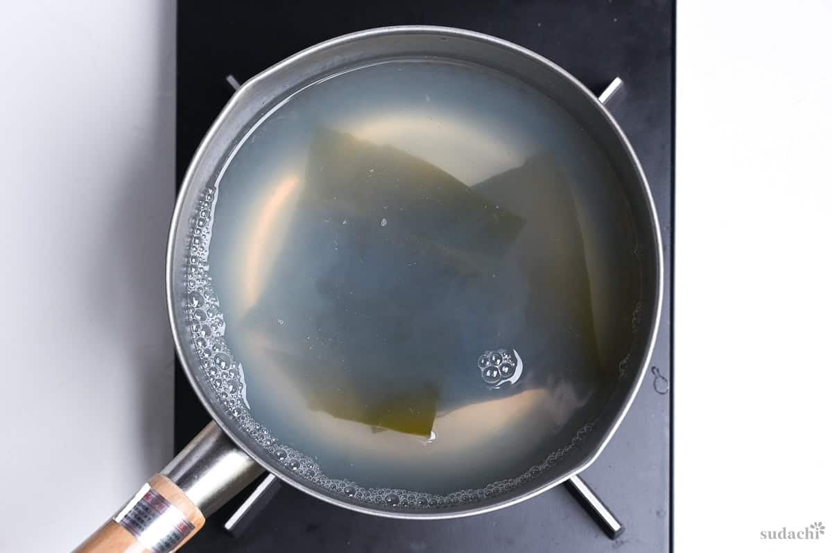clam stock and kombu dashi combined in a saucepan on the stove top