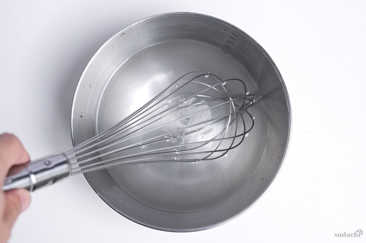 whisking salt into water in a mixing bowl