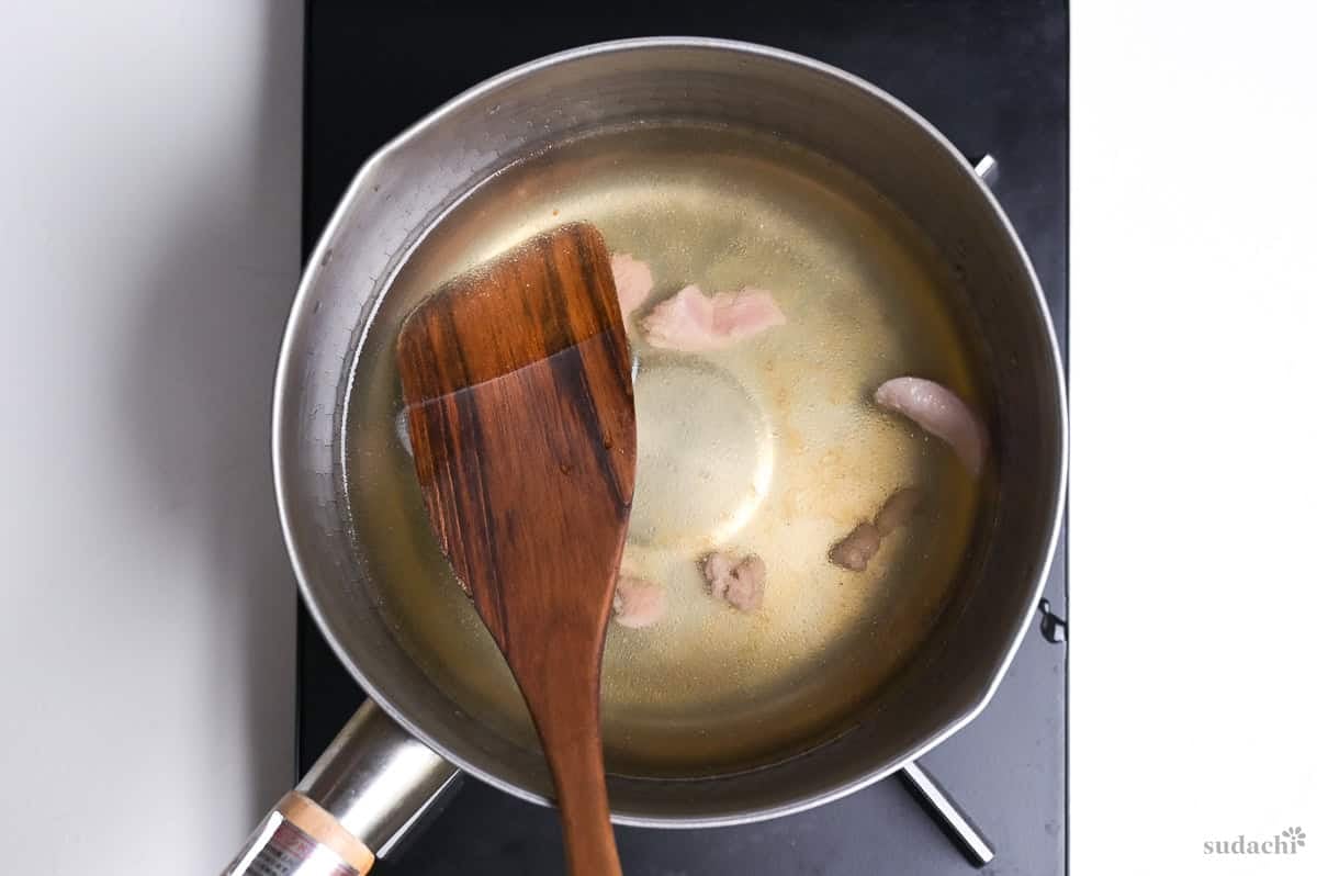 duck breast scraps in dashi in a saucepan on the stove top
