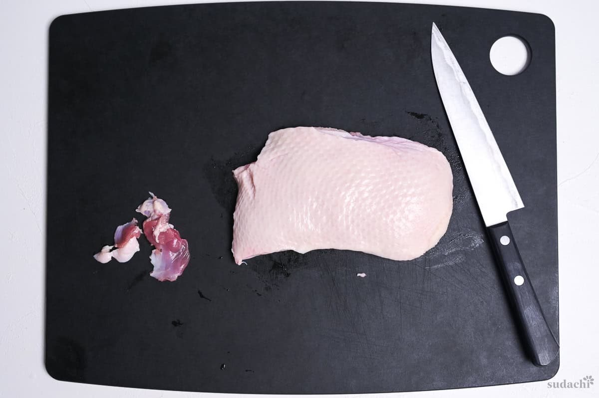 duck breast trimmed scraps on a black cutting board