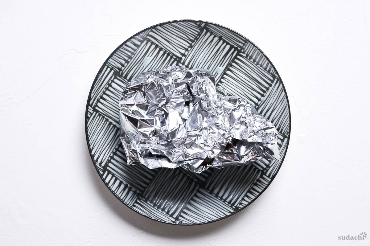 pan fried duck breast wrapped in foil, resting on a plate to finish cooking