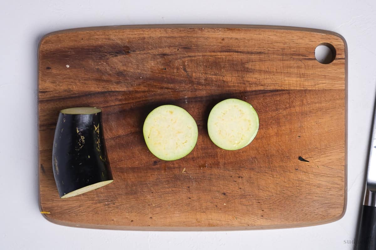 two eggplant rounds cut on a wooden cutting board