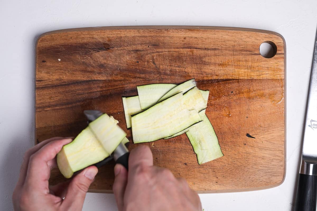 making thin slices of Japanese eggplant using a peeler