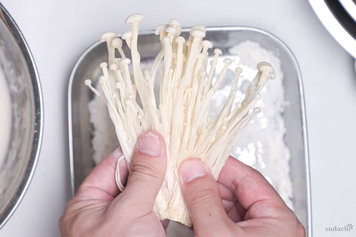 A small bunch of enoki mushrooms fanned out before coating with tempura batter