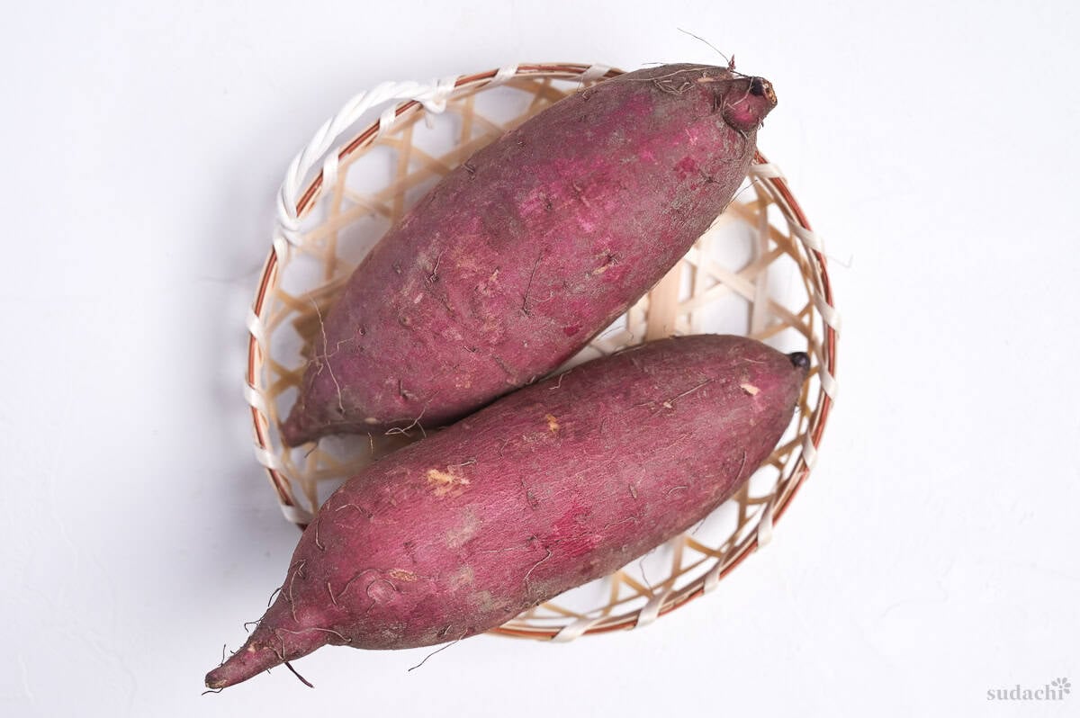 Two Japanese sweet potatoes in a small woven basket