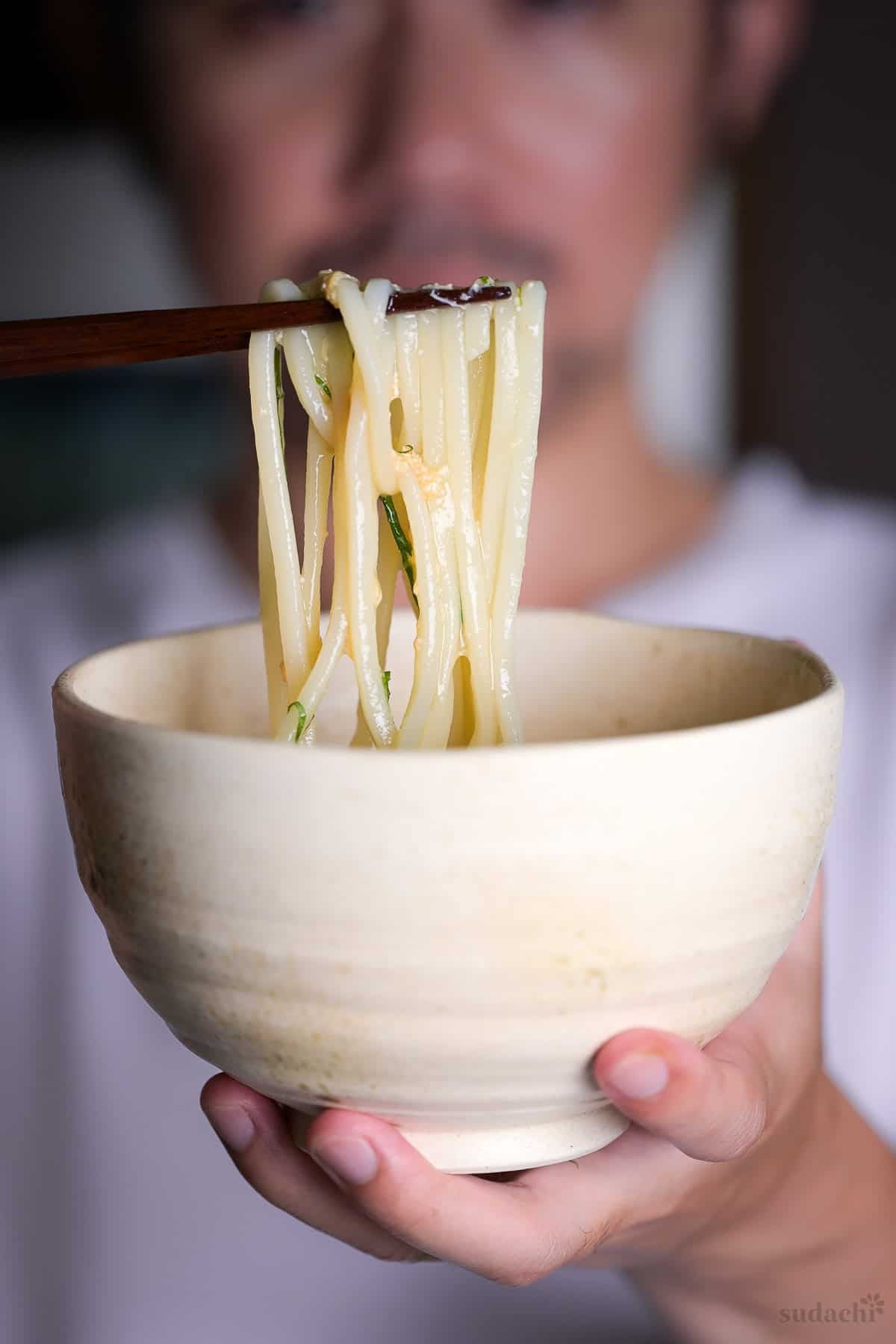 Yuto Omura holding up a bowl of mentaiko ankake udon