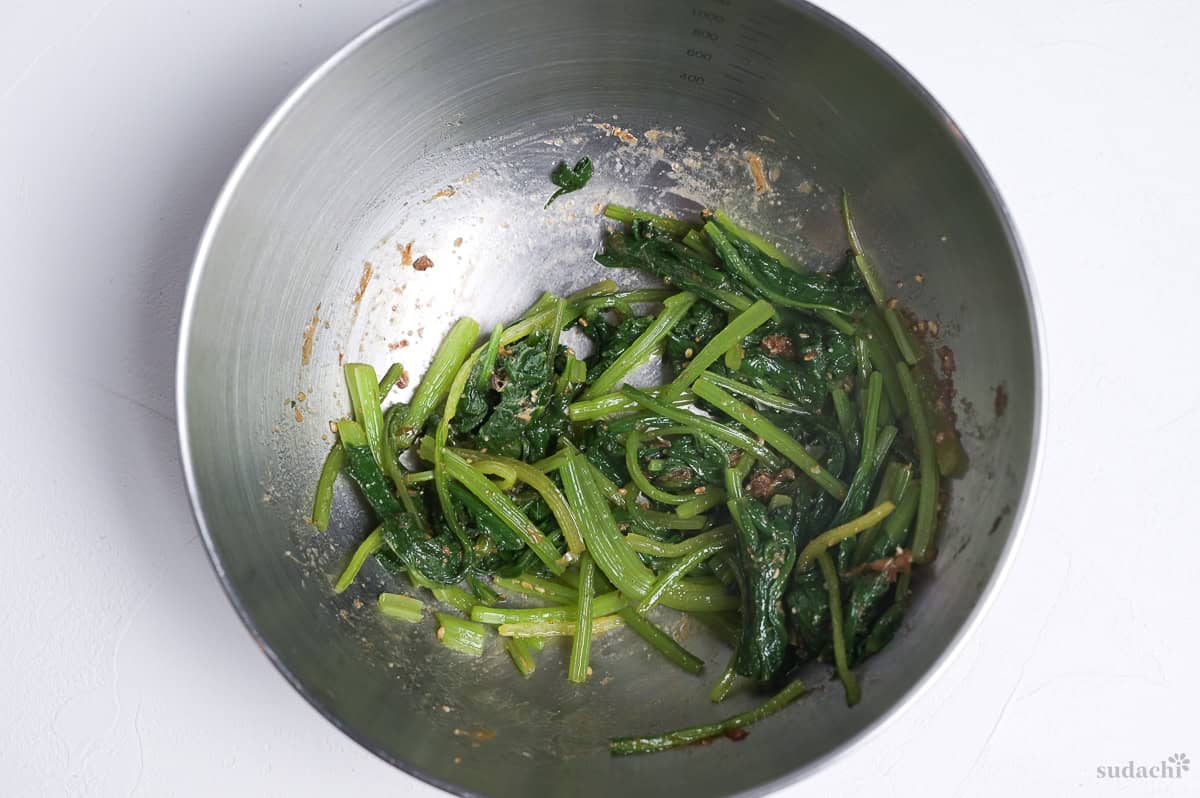 Blanched Oriental spinach coated with sesame sauce in a bowl.