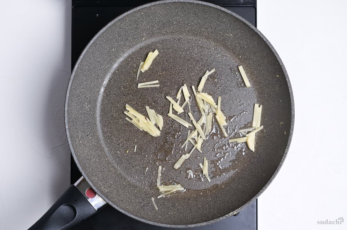 frying julienned ginger in a frying pan until fragrant.