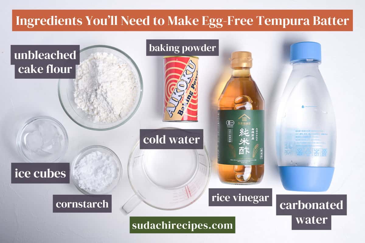 Ingredients needed to make shojin age on a white background with labels. From top to bottom, left to right: unbleaches cake flour, baking powder, ice cubes, cold water, cornstarch, rice vinegar, carbonated water.