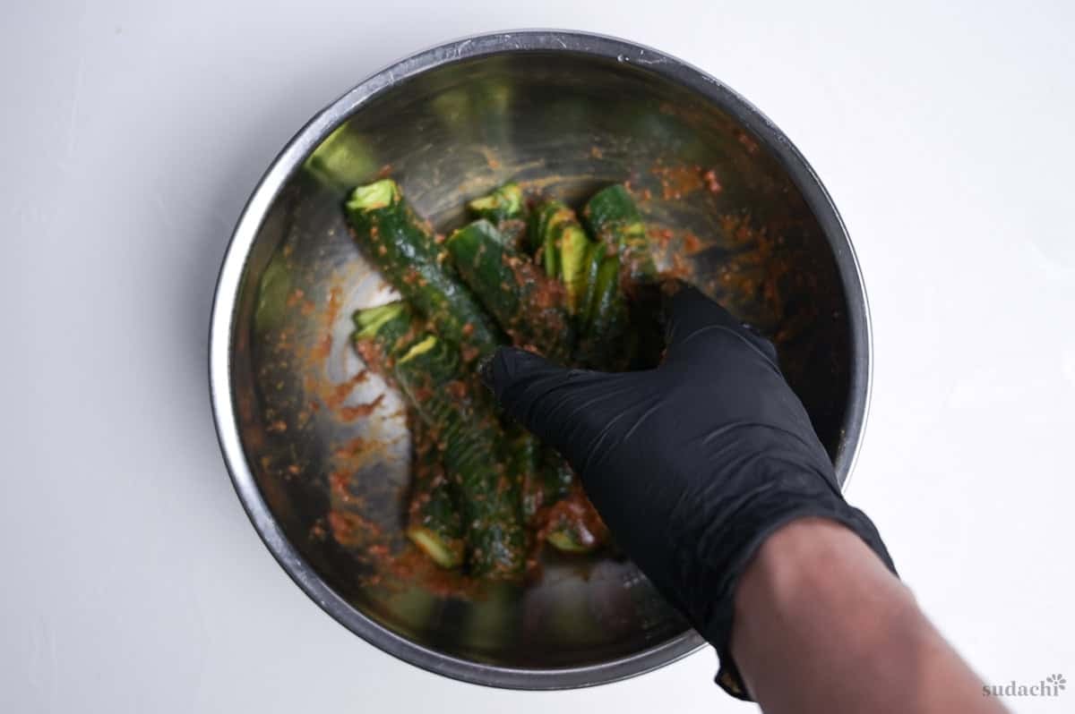 rubbing accordion cucumbers with spicy miso marinade