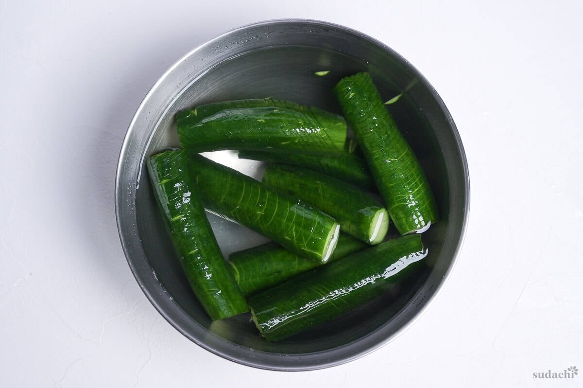 soaking accordion cucumbers in salt water in a steel mixing bowl